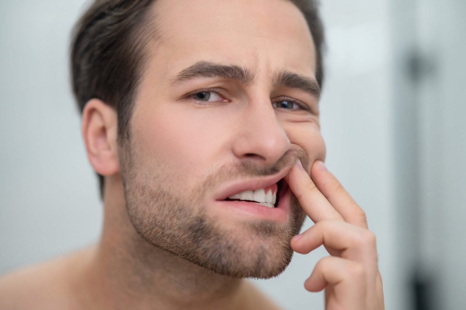 A man with a concerned expression illustrates a common concern for Bleeding Gums in Beverly Hills.